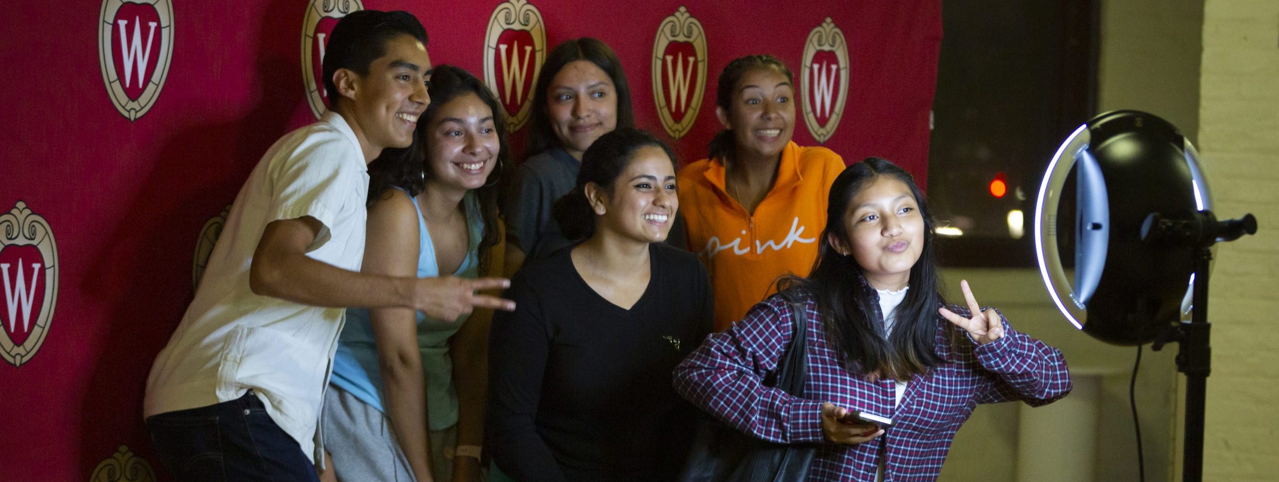 Students pose for a picture at a photo station set up at the Latinx Student Welcome event in the Red Gym at the University of Wisconsin–Madison