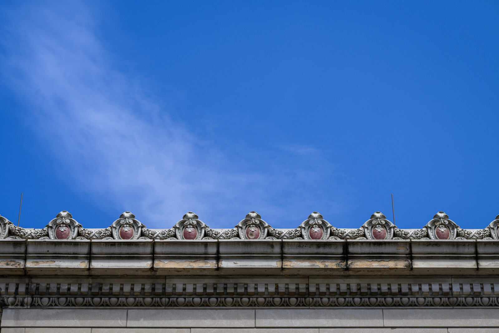 Wisconsin crests line the roofline of the Memorial Union in front of blue sky