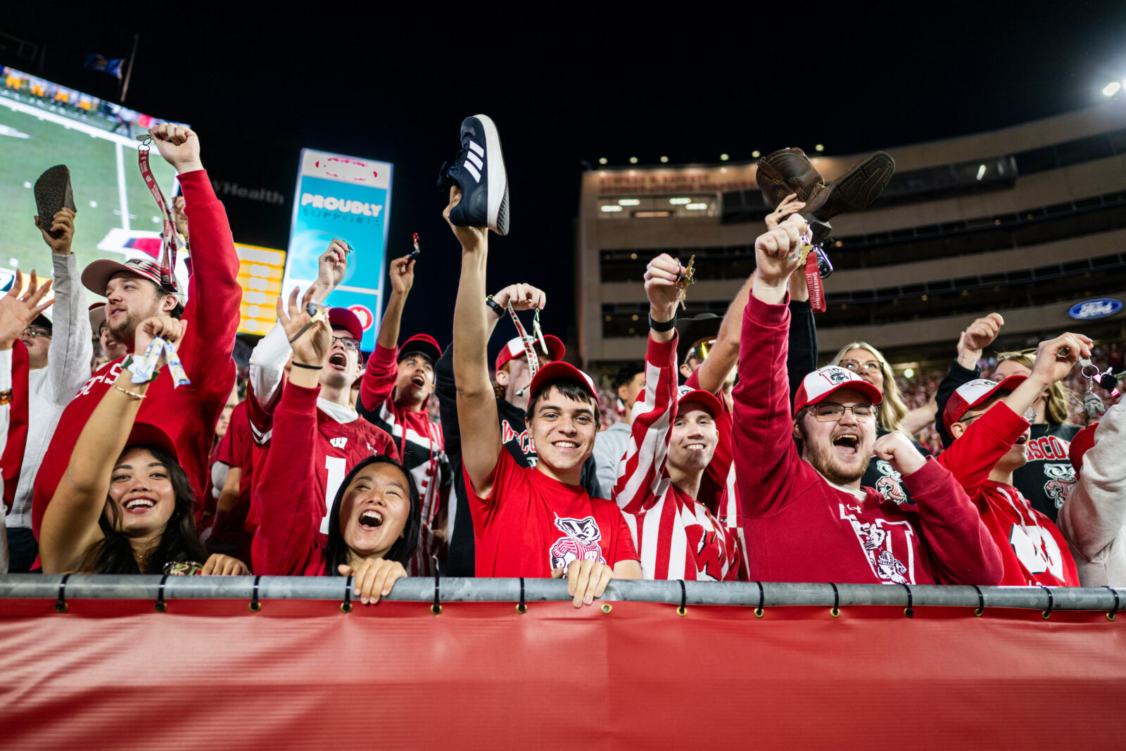 Students hold up keychains and shoes during kickoff at the Homecoming football game versus Iowa in Camp Randall Stadium