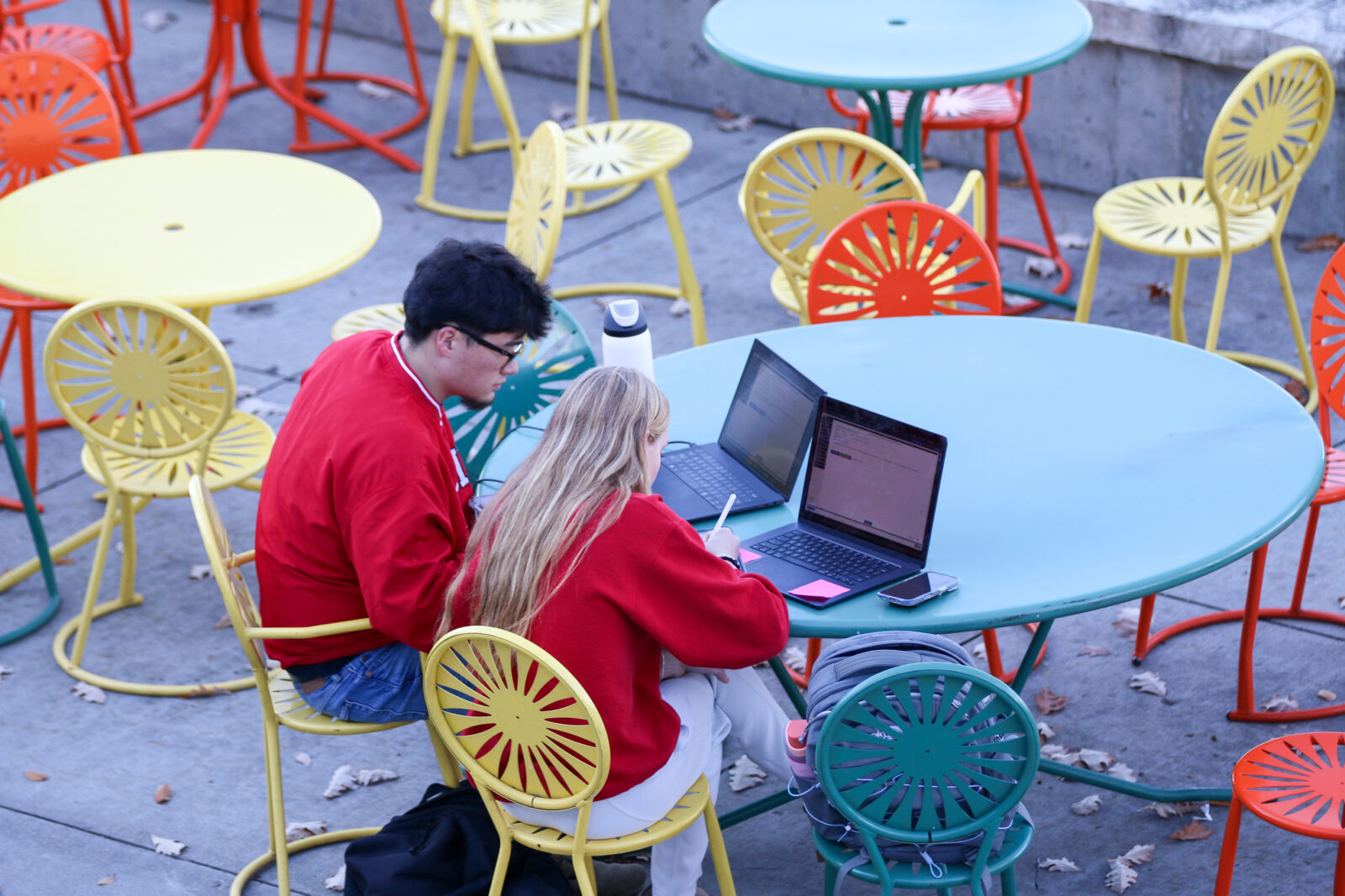Two students study at their laptops at the Memorial Union Terrace