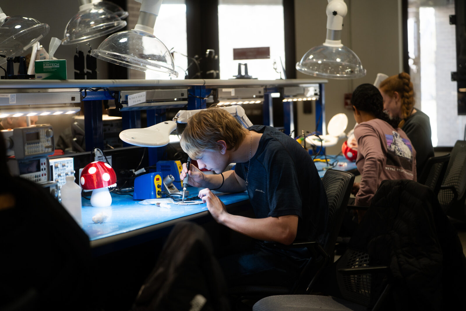 A student welds a lamp at the Design Innovation Lab