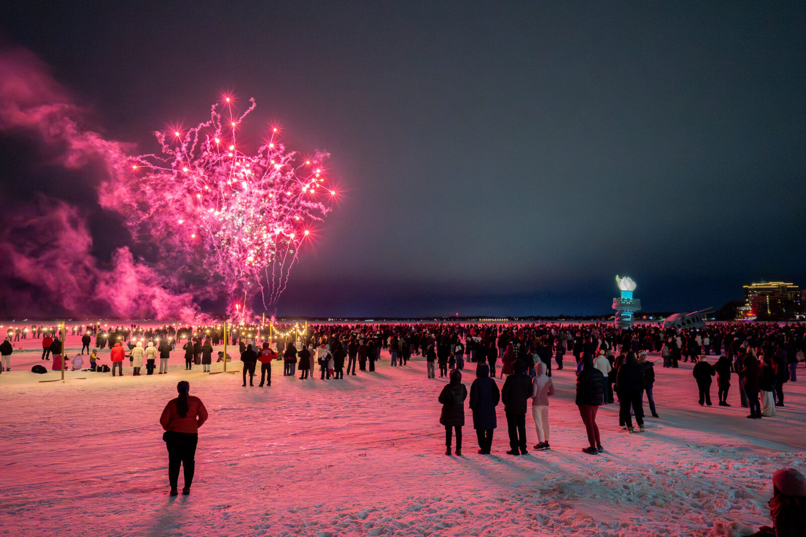 Fireworks are seen above viewers on a frozen Lake Mendota